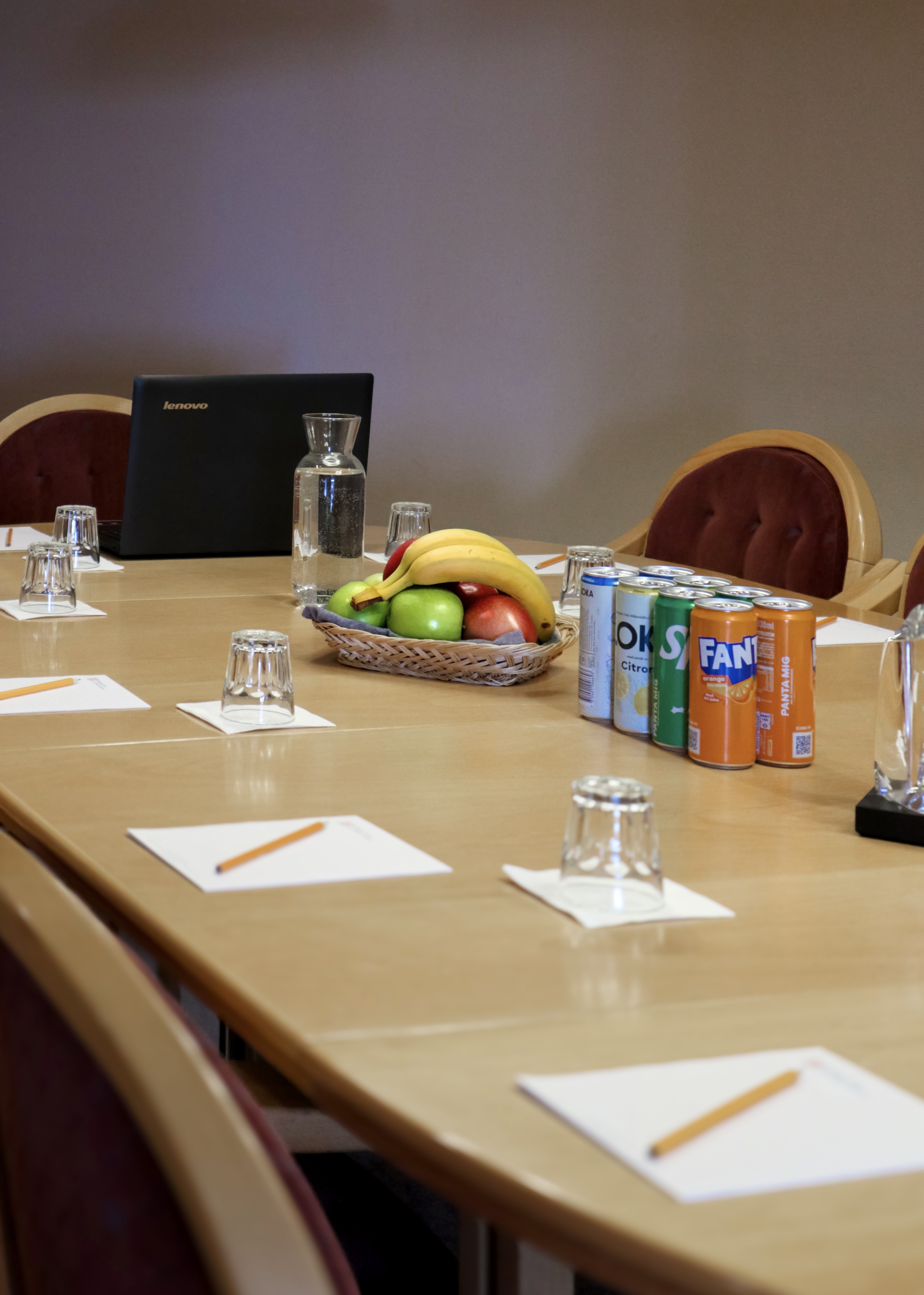 Mötesbordet dukat med frukt, anteckningsblock och vatten